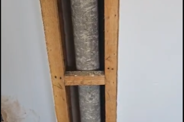 Exposed plumbing pipe framed in wooden structure